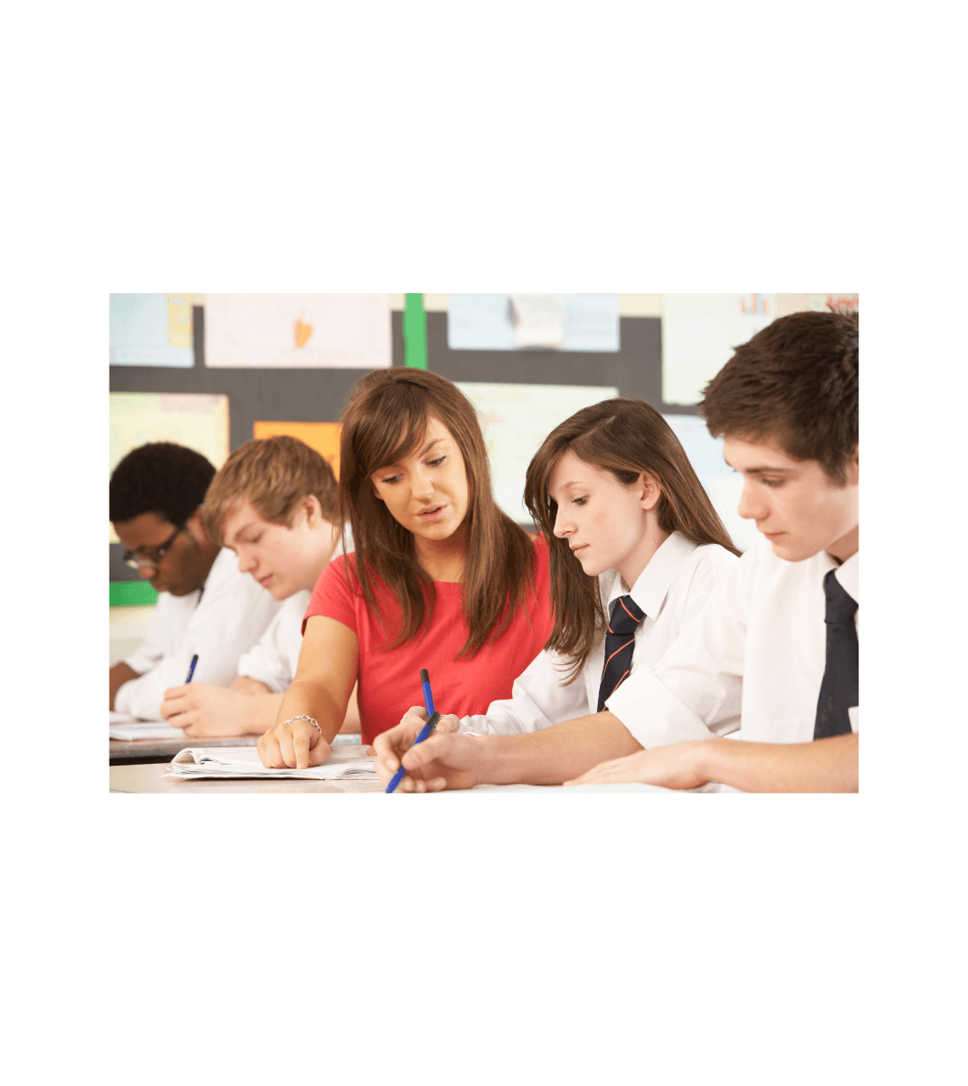 Teacher assisting secondary students with written work in a classroom setting, supporting learning from A World of Beliefs.