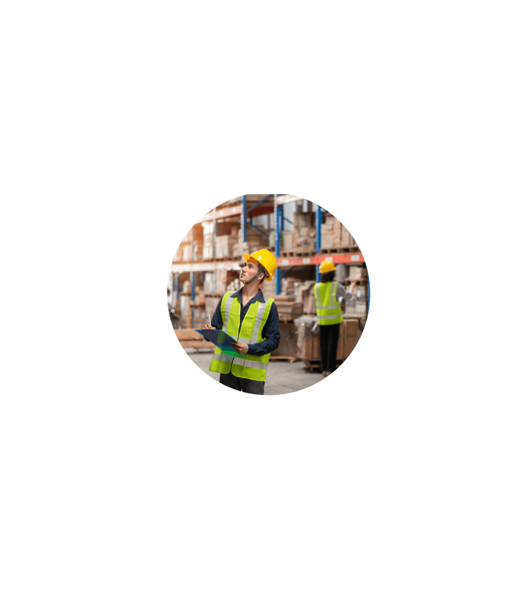 Warehouse worker in a yellow safety vest and hard hat holding a clipboard while inspecting shelves stacked with boxes.