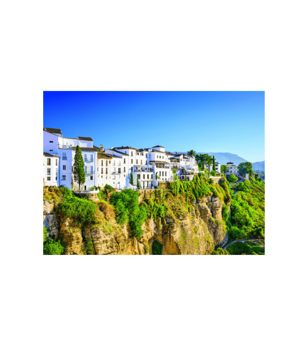 Whitewashed buildings of Ronda perched atop dramatic cliffs in Andalusia, Spain, under a bright blue sky.