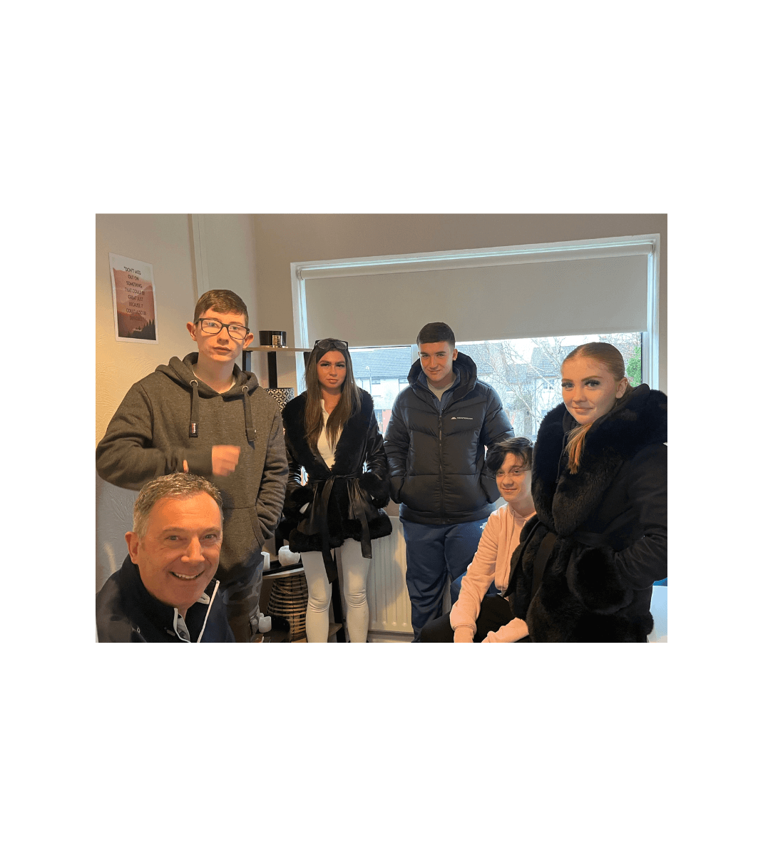 Group of teens and a mentor gathered indoors at Youth Horizons, fostering support and connection in a welcoming environment.